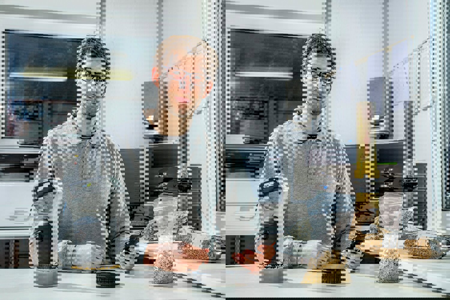 Man at a desk checking the results of his tested material with the NutriOpt handheld scanner