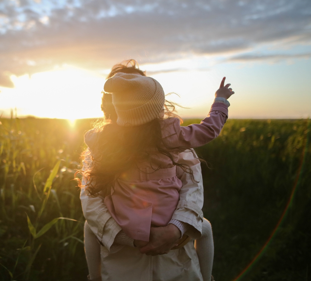 Child pointing at sunset